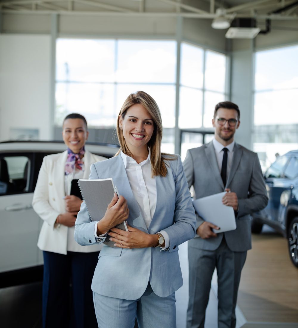 salesteam-in-dealership-three-beautiful-consultants-or-managers-in-elegant-suit-looking-on-camera-